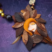 FOREST FAIRIES are ONE OF A KIND Artisan Necklaces. A sweet little fairy is caught napping in her nest of leaves. Each is a one of a kind piece of wearable art with her own unique look and personality. The faces are hand-painted and then surrounded by hand-cut leaves and collected beads, gemstones and sculpted treasures.
