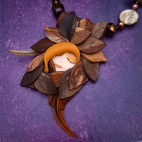 FOREST FAIRIES are ONE OF A KIND Artisan Necklaces. A sweet little fairy is caught napping in her nest of leaves. Each is a one of a kind piece of wearable art with her own unique look and personality. The faces are hand-painted and then surrounded by hand-cut leaves and collected beads, gemstones and sculpted treasures.