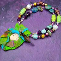 FOREST FAIRIES are ONE OF A KIND Artisan Necklaces. A sweet little fairy is caught napping in her nest of leaves. Each is a one of a kind piece of wearable art with her own unique look and personality. The faces are hand-painted and then surrounded by hand-cut leaves and collected beads, gemstones and sculpted treasures. By Studio Navarri