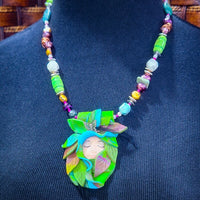 FOREST FAIRIES are ONE OF A KIND Artisan Necklaces. A sweet little fairy is caught napping in her nest of leaves. Each is a one of a kind piece of wearable art with her own unique look and personality. The faces are hand-painted and then surrounded by hand-cut leaves and collected beads, gemstones and sculpted treasures. By Studio Navarri