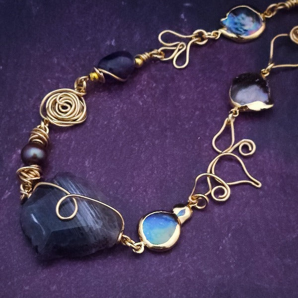 Feel empowered and beautiful wearing our exquisite Zasha Gemstone Collar, meticulously crafted with 14K gold-filled and stunning Amethyst gemstones. The hand-sculpted wire details, reminiscent of delicate flower petals, make this piece truly one of a kind. With a touch of elegance and sophistication, this statement collar will turn heads. 