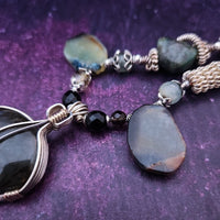 We all have a light within, an inner glow that others may see when they connect with our spirit. The shimmer and glow of this Labradorite Cabochon reminds me of this. This asymmetrical collar necklace is a testament to artisan craftsmanship and design. The Labradorite Cabochon is encased in a Wire Wrapped setting with a beautifully fluid look, and sterling silver coiled pieces add a unique look.