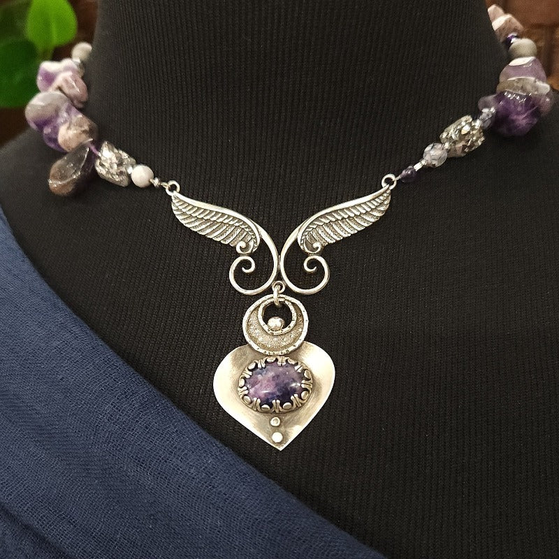 Let your inner goddess shine with this one-of-a-kind Velavee Angel Necklace! Exquisitely crafted from sterling silver and the rare Charoite gemstone, the necklace features an angel wing and an inverted fan shaped medallion for a stunning, unique look. Ready to ship, shine brighter than ever with this divine accessory!