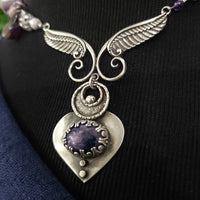 Let your inner goddess shine with this one-of-a-kind Velavee Angel Necklace! Exquisitely crafted from sterling silver and the rare Charoite gemstone, the necklace features an angel wing and an inverted fan shaped medallion for a stunning, unique look. Ready to ship, shine brighter than ever with this divine accessory!