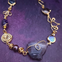 Feel empowered and beautiful wearing our exquisite Zasha Gemstone Collar, meticulously crafted with 14K gold-filled and stunning Amethyst gemstones. The hand-sculpted wire details, reminiscent of delicate flower petals, make this piece truly one of a kind. With a touch of elegance and sophistication, this statement collar will turn heads. 