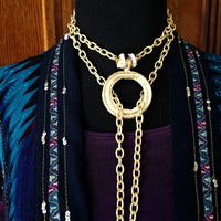 THE 5th AVENUE LARIAT is bold and dramatic, and will definitely get some attention. A large circular disc attached to gold Brittanium chain with both wafer and large freshwater pearls. Simply place the circle where you want it, wrap the chain around your neck and slide the ends thru the circle. Voila! Instant Fashionista!