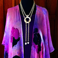 THE 5th AVENUE LARIAT is bold and dramatic, and will definitely get some attention. A large circular disc attached to gold Brittanium chain with both wafer and large freshwater pearls. Simply place the circle where you want it, wrap the chain around your neck and slide the ends thru the circle. Voila! Instant Fashionista!
