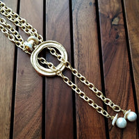 THE 5th AVENUE LARIAT is bold and dramatic, and will definitely get some attention. A large circular disc attached to gold Brittanium chain with both wafer and large freshwater pearls. Simply place the circle where you want it, wrap the chain around your neck and slide the ends thru the circle. Voila! Instant Fashionista!