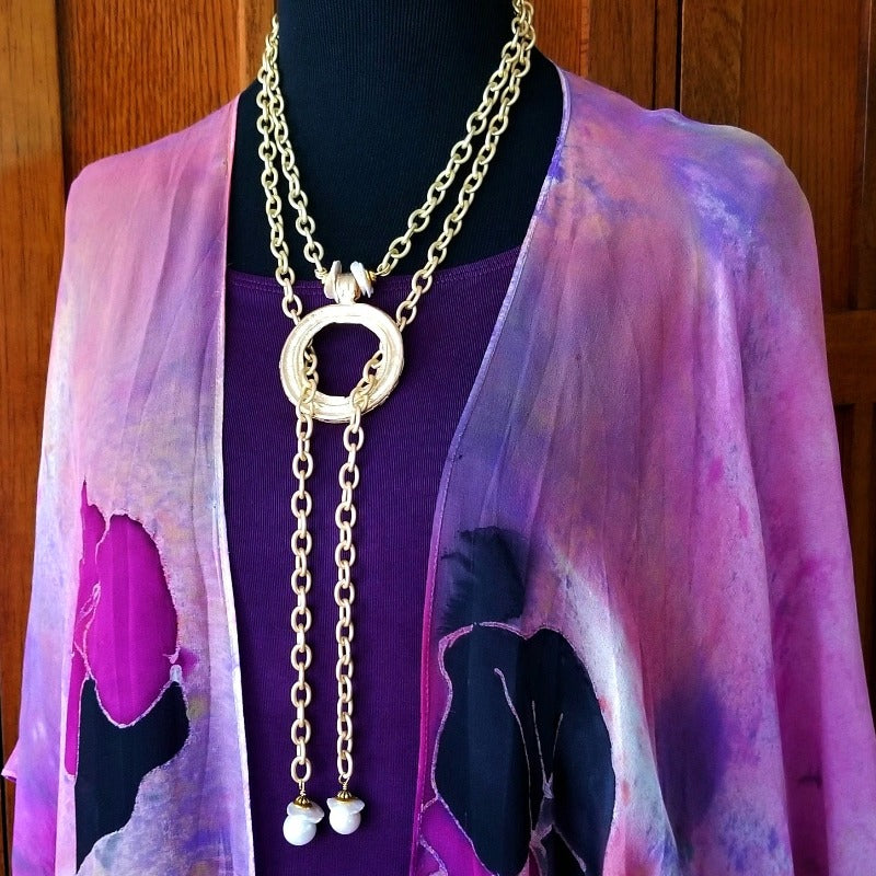THE 5th AVENUE LARIAT is bold and dramatic, and will definitely get some attention. A large circular disc attached to gold Brittanium chain with both wafer and large freshwater pearls. Simply place the circle where you want it, wrap the chain around your neck and slide the ends thru the circle. Voila! Instant Fashionista!