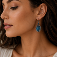 Close-up of a woman wearing a blue earring with a neutral background