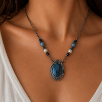 Necklace with a blue pendant worn by a person in a white top