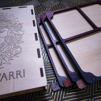 Laser-cut wooden jewelry box components and inner trays, including a lid engraved with floral detailing and the word 'YARRI', shown on a patterned dark surface.