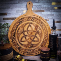 Wooden cutting board with Celtic knot design on a rustic background