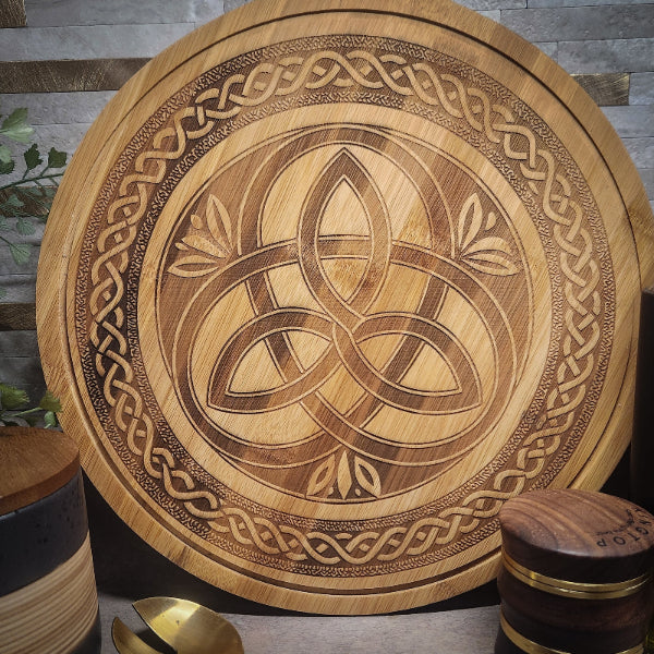 Wooden cutting board with Celtic knot design on a wooden surface