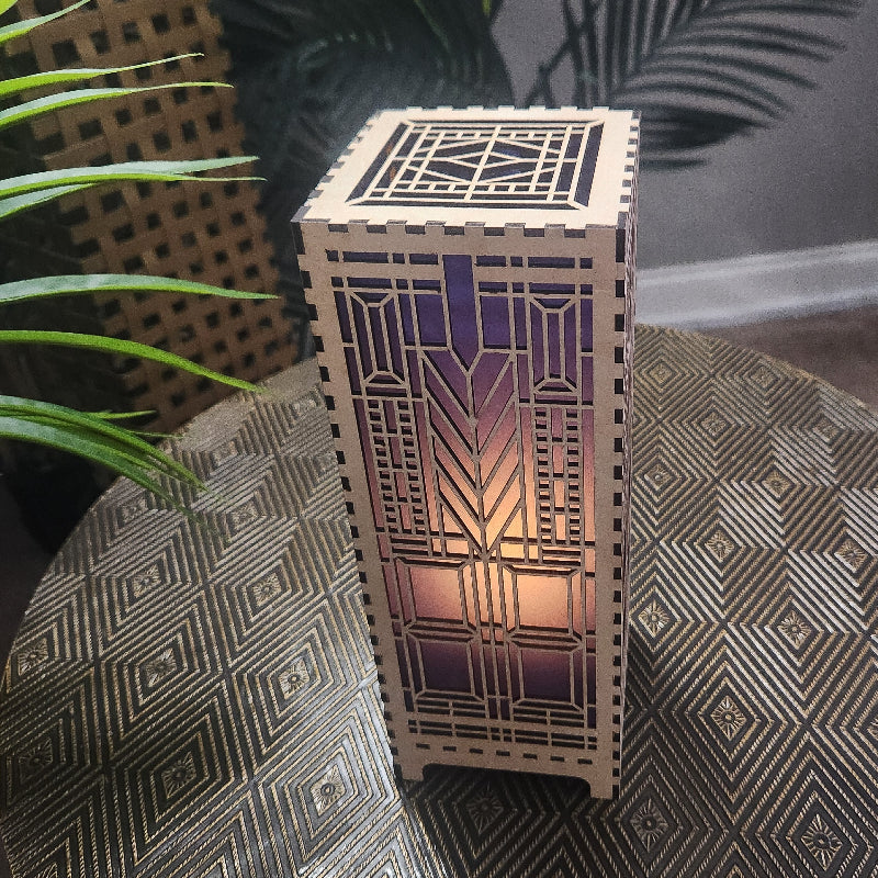 Domara LED lamp with Frank Lloyd Wright inspired Arts and Craftsman styled lamp on a dark surface next to a  plant - top view