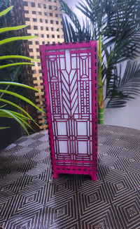Pink decorative screen with geometric pattern on a textured floor