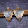 Copper is hand cut and sculpted, then embossed with unique patterns. The pieces are then kissed with a torch to create beautiful, vibrant colors