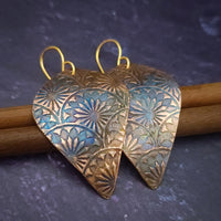 Copper is hand cut and sculpted, then embossed with unique patterns. The pieces are then kissed with a torch to create beautiful, vibrant colors