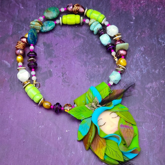 FOREST FAIRIES are ONE OF A KIND Artisan Necklaces. A sweet little fairy is caught napping in her nest of leaves. Each is a one of a kind piece of wearable art with her own unique look and personality. The faces are hand-painted and then surrounded by hand-cut leaves and collected beads, gemstones and sculpted treasures. By Studio Navarri