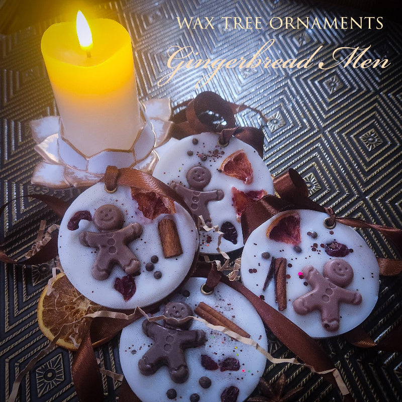 Wax tree ornaments shaped like gingerbread men with a lit candle on a decorative background.