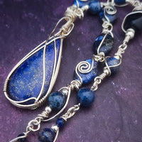 DEEP BLUE like midnight skies and ocean depths.  This asymmetrical collar necklace is a testament to artisan craftsmanship and design. The Lapis Lazuli Cabochon is encased in a Wire Wrapped setting with a beautifully fluid look, And the gemstones are embellished with sterling silver adding a unique look.