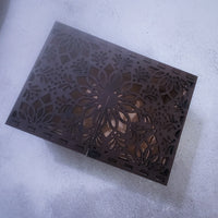 Decorative metal grille with intricate cut-out design on a concrete surface