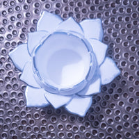 Blue flower-shaped object on a textured metal surface