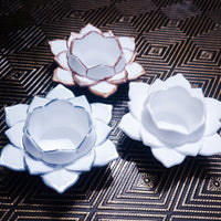 Three ceramic lotus flowers on a textured surface
