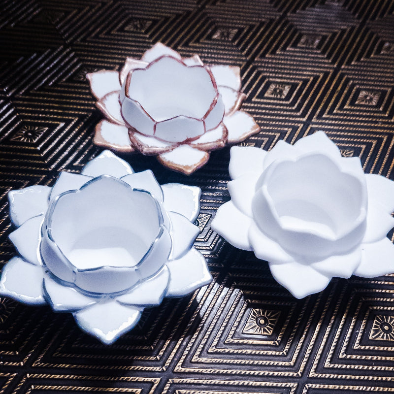 Three ceramic lotus flowers on a textured surface