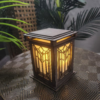 Decorative lantern with geometric pattern on a textured surface with plants in the background
