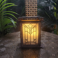 Decorative lantern with geometric pattern on a textured surface with plants in the background