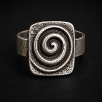 A textured sterling silver ring featuring a square face with a raised spiral design, photographed on a dark black background.