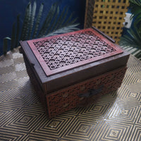 Decorative wooden box with intricate carvings on a patterned surface