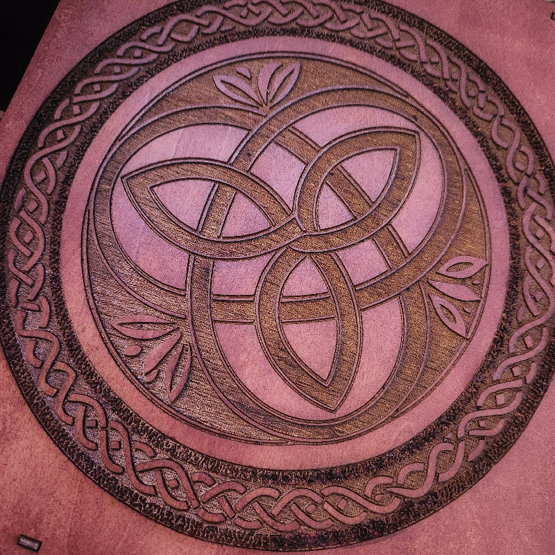 Decorative circular design with interwoven patterns on a teak wood background