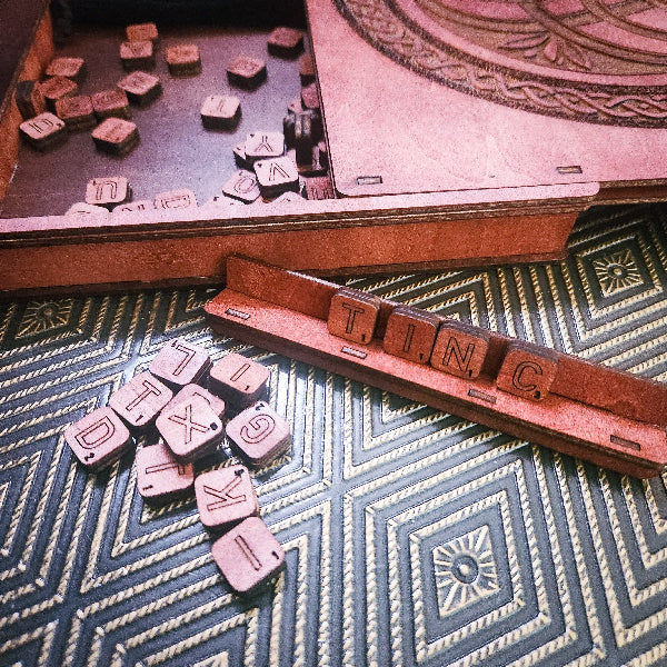 Wooden Scrabble tiles with a decorative box on a patterned surface