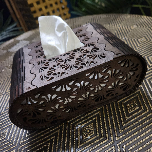 Decorative tissue box with intricate cut-out patterns on a textured surface
