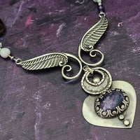 Let your inner goddess shine with this one-of-a-kind Velavee Angel Necklace! Exquisitely crafted from sterling silver and the rare Charoite gemstone, the necklace features an angel wing and an inverted fan shaped medallion for a stunning, unique look. Ready to ship, shine brighter than ever with this divine accessory!