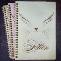 Notebook with 'Kitten' design on a dark textured surface