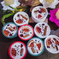 Assorted candles with winter spice decorative elements 