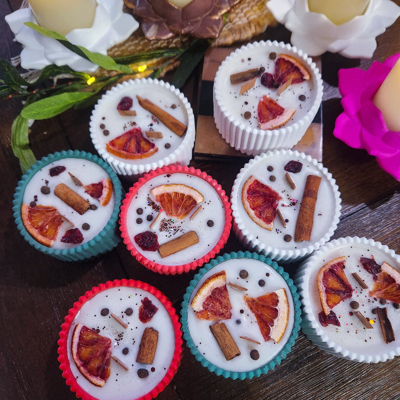 Assorted candles with winter spice decorative elements 