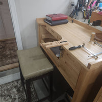 Wooden workbench with tools and a stool in a workshop setting