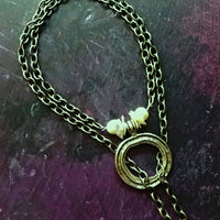 THE 5th AVENUE LARIAT is bold and dramatic, and will definitely get some attention. A large circular disc attached to gold Brittanium chain with both wafer and large freshwater pearls. Simply place the circle where you want it, wrap the chain around your neck and slide the ends thru the circle. Voila! Instant Fashionista!