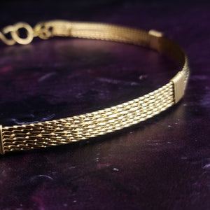 This handcrafted collar is crafted from 14k gold filled wire, expertly twisted for a unique and beautiful T. The addition of a chain in the back ensures the collar moves effortlessly with you and provides a comfortable fit. ASHANTI is the perfect base for bold and versatile outfit combinations; it can be kept simple by wearing it alone, or layer it with pendants and chains to take your look to the next level.
