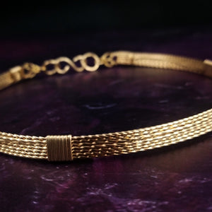 This handcrafted collar is crafted from 14k gold filled wire, expertly twisted for a unique and beautiful T. The addition of a chain in the back ensures the collar moves effortlessly with you and provides a comfortable fit. ASHANTI is the perfect base for bold and versatile outfit combinations; it can be kept simple by wearing it alone, or layer it with pendants and chains to take your look to the next level.