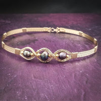 Elegantly crafted with 14k gold filled wire and large freshwater pearls of a peacock hue, this collar is a bold yet delicate accent to add femininity to any outfit. Secured with a hook and eye closure. From everything from your jeans and tee to your wedding dress!