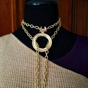 THE 5th AVENUE LARIAT is bold and dramatic, and will definitely get some attention. A large circular disc attached to gold Brittanium chain with both wafer and large freshwater pearls. Simply place the circle where you want it, wrap the chain around your neck and slide the ends thru the circle. Voila! Instant Fashionista!