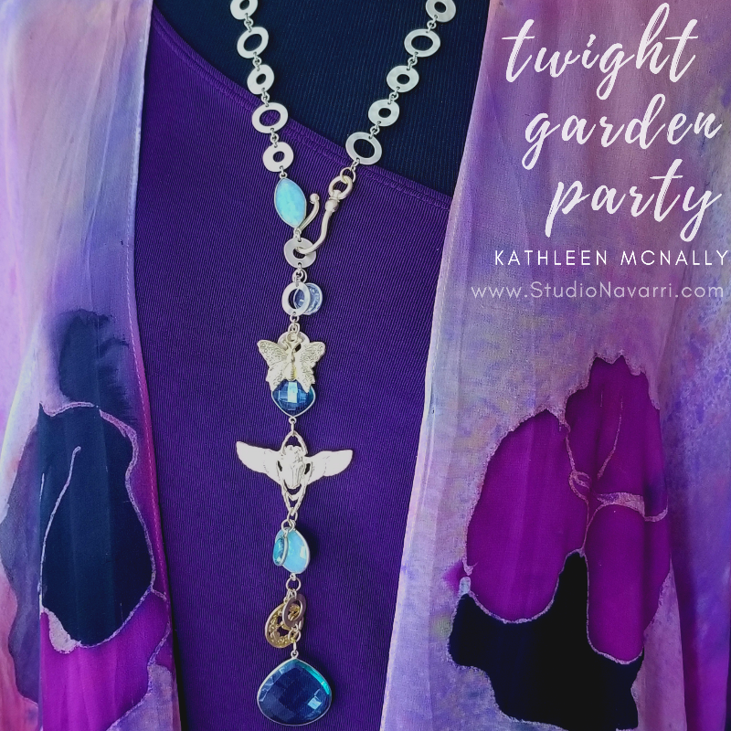 The scent of lavender and roses in the evening breeze. Golden sandals on the garden path. This garden themed necklace will glow with the reflection of the evening sun and garden torches. A chain of golden soft cornered squares and circles, a butterfly, a lunar moth and a sweet hummingbird medallion, all intermingle with faceted crystals in clear, pale blue, and aquamarine colors. Finished with a large, faceted blue crystal.