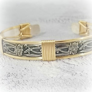 This artisan wrist cuff is skilfully hand-crafted with a timeless floral pattern for classic feminine charm. Featuring sterling silver with 14k gold filled wire-wrapped accents, this is an exquisitely durable piece that will remain a treasured part of your collection.