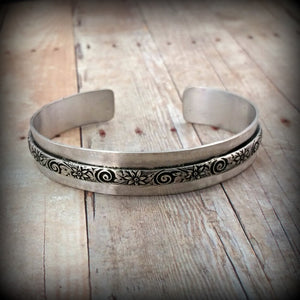 Wild Flower Wide Sterling Silver Cuff Bracelet. Luxurious solid sterling silver in a nice and heavy 19 gauge, the cuff measures approx. 3/4" wide with a floral center soldered onto the cuff. Oxidized to add depth and detail.